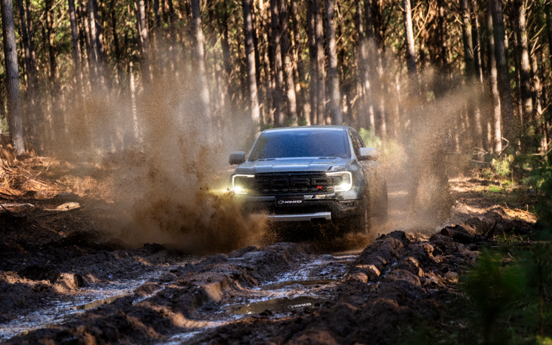 Caminhonete enfrenta trilha enlameada em floresta densa, destacando potência e resistência, cenário perfeito para demonstrar acessórios para carro de aventura que garantem desempenho, segurança e estilo off-road.